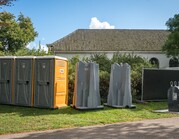 Mobiele toiletten op evenemententerrein, met als aanvulling losse urinoirs.